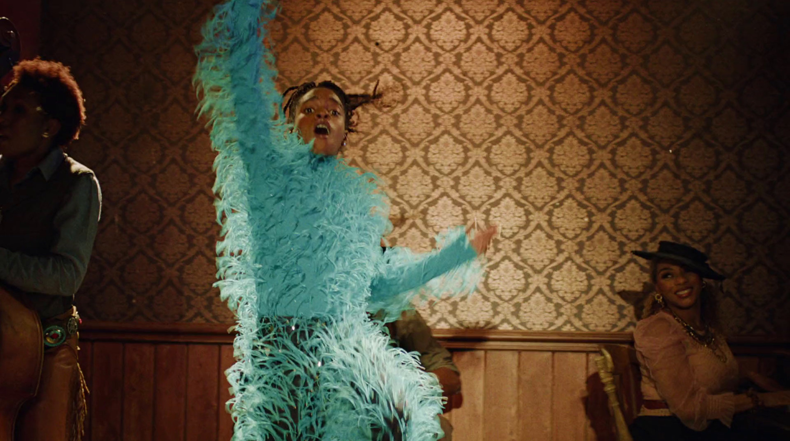 a man in a blue feathered costume standing next to a woman