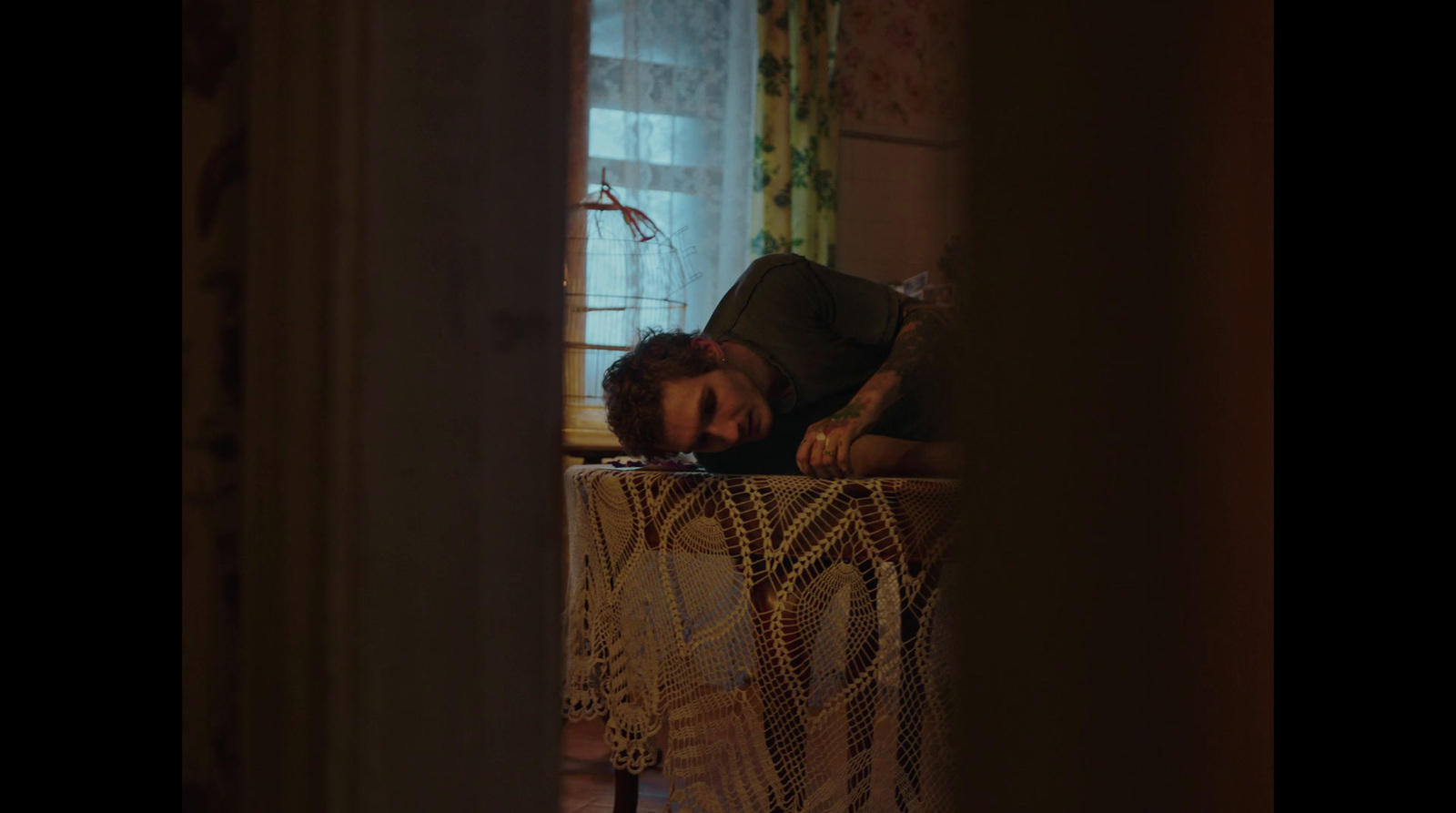 a man laying on top of a table next to a window