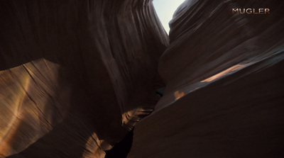 a man riding a skateboard through a narrow canyon