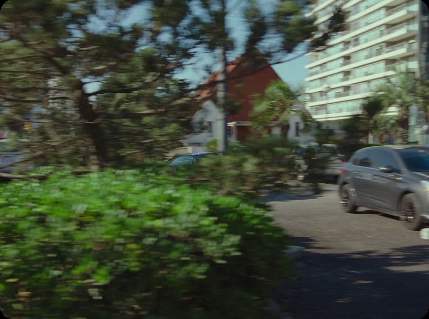 a car driving down a street next to tall buildings