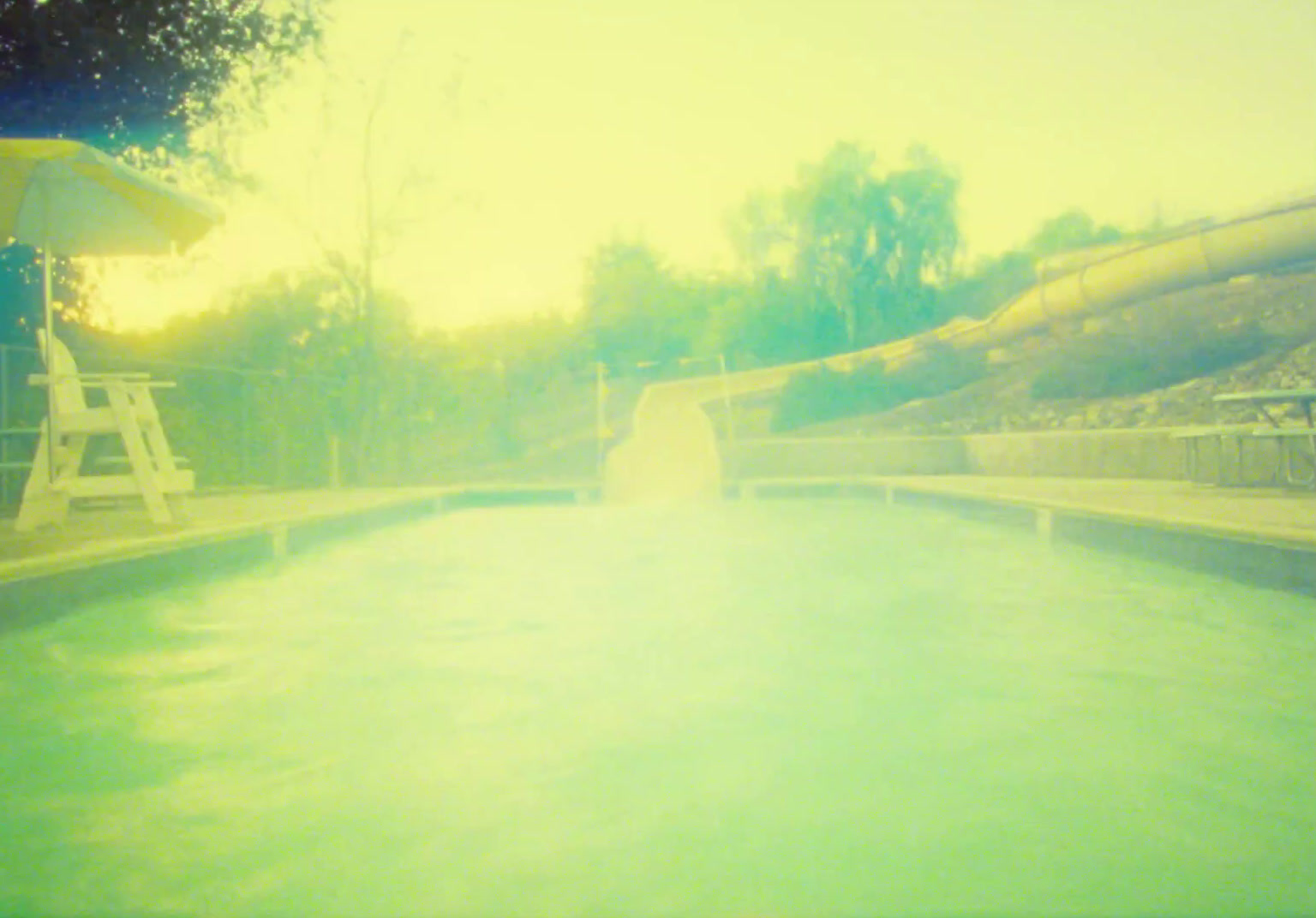 a large pool with a slide in the background