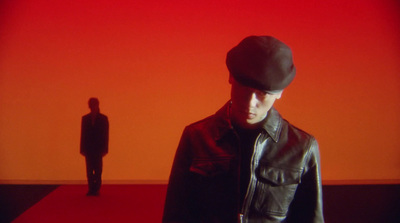 a man standing in front of a red wall