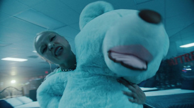 a woman holding a large blue teddy bear