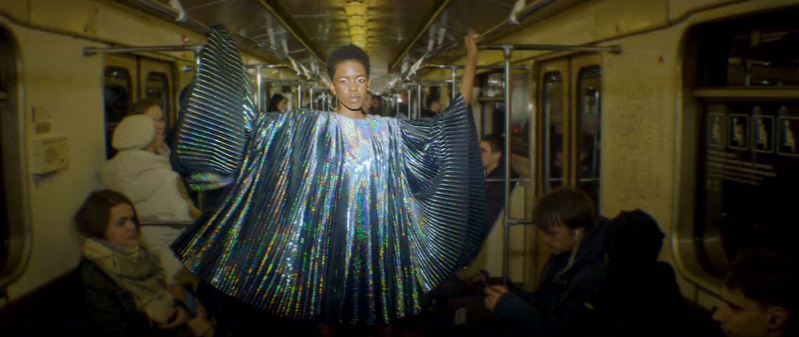 a woman in a shiny dress on a subway