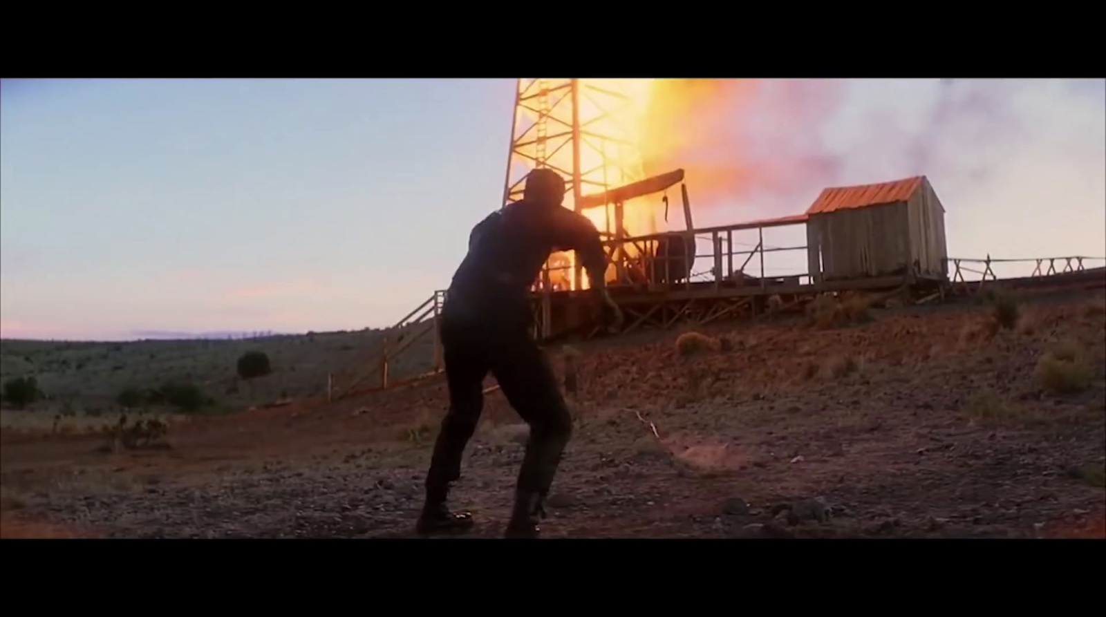 a man standing in front of a burning building