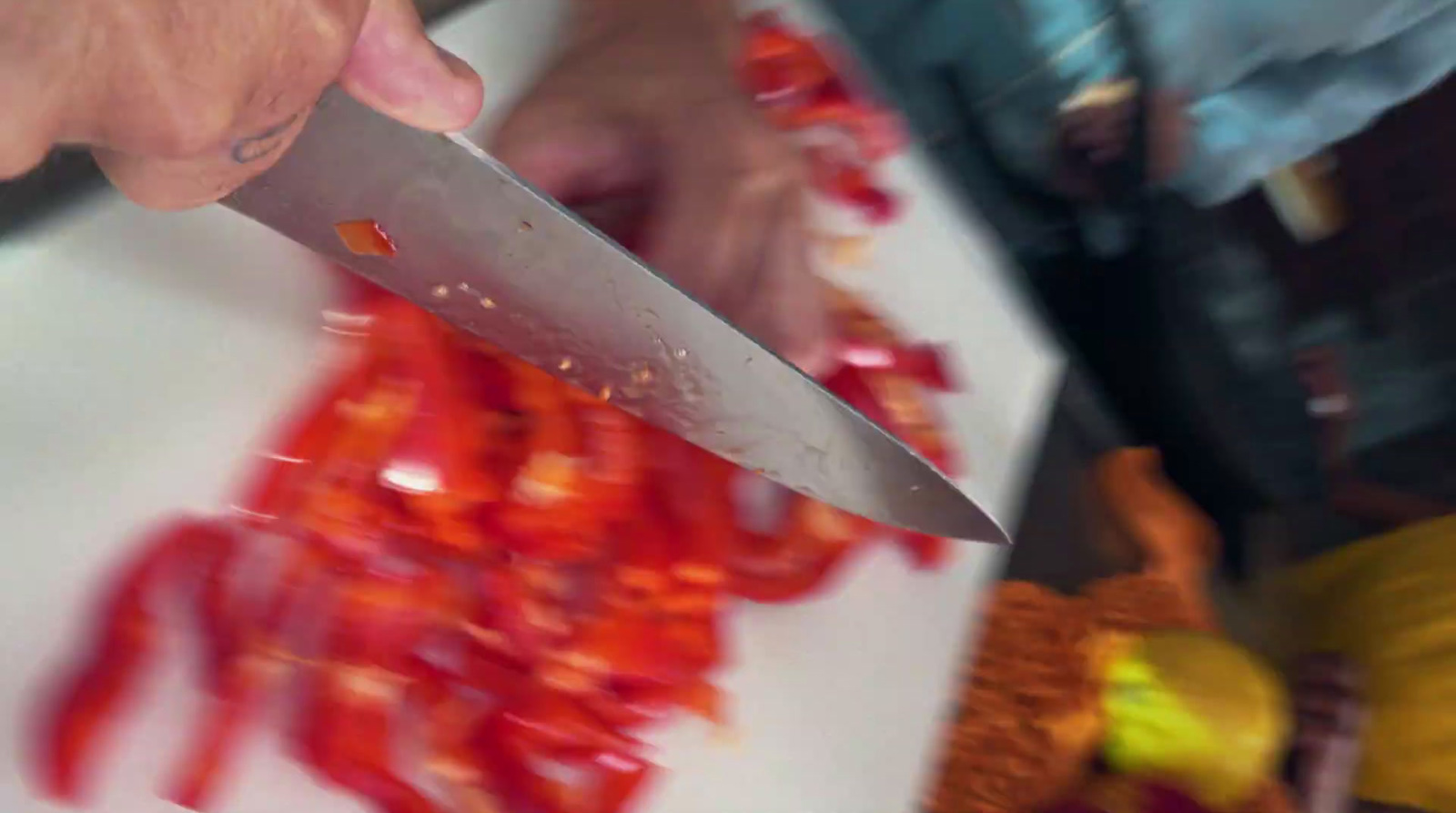 a person holding a knife over a cutting board