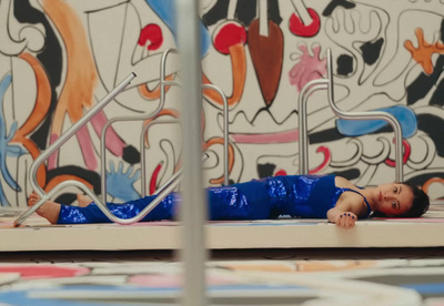 a small child laying on the ground in front of a wall