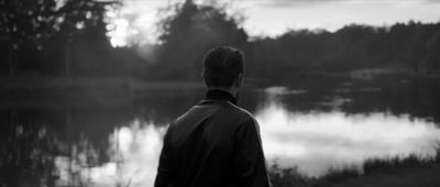 a man standing in front of a body of water