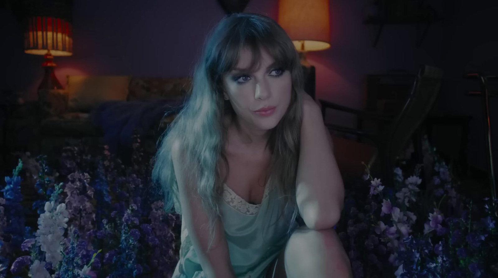 a woman sitting on a bed of purple flowers