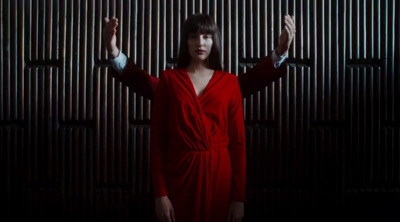 a woman in a red dress standing in front of a wall