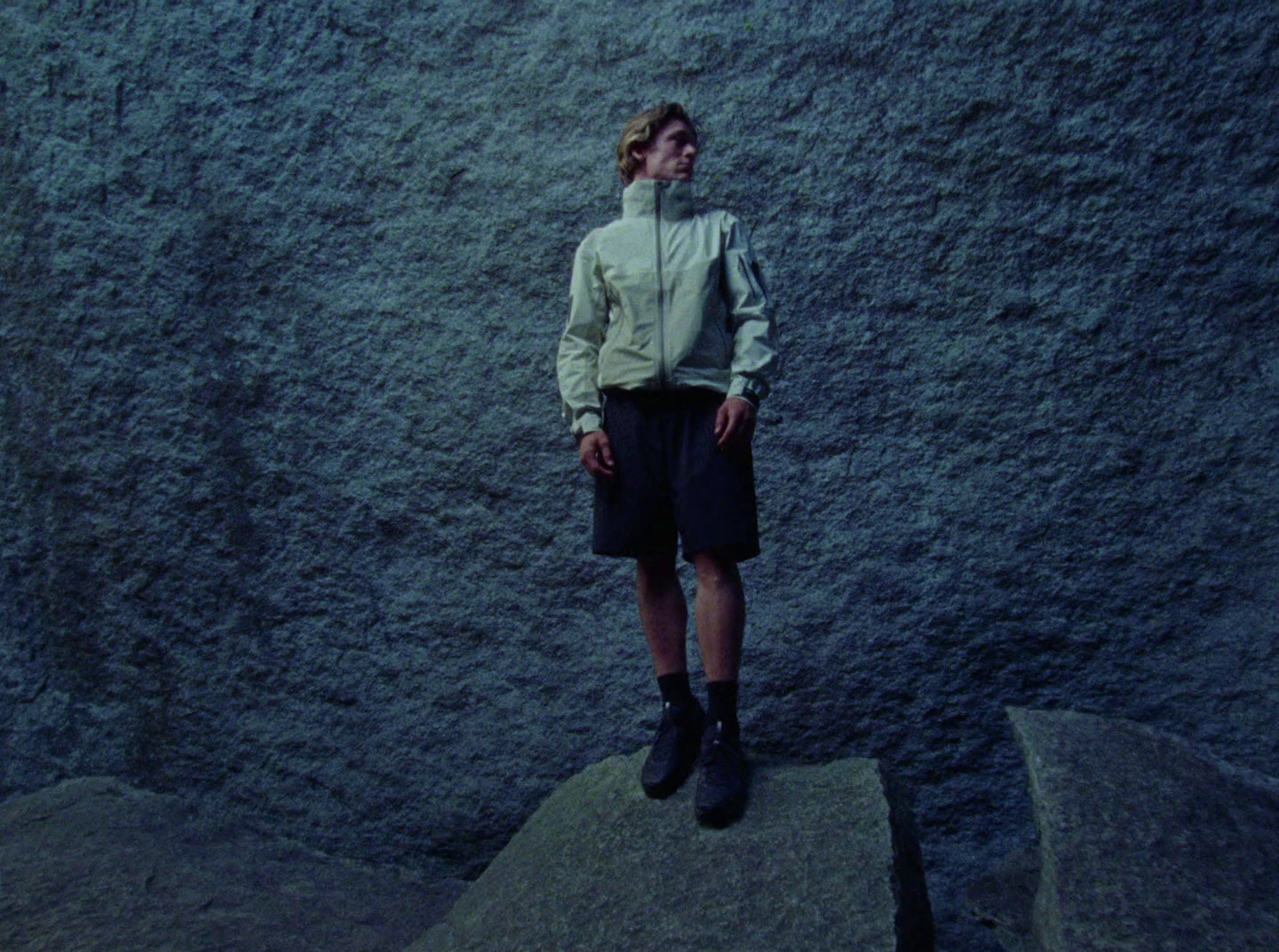 a woman standing on top of a large rock