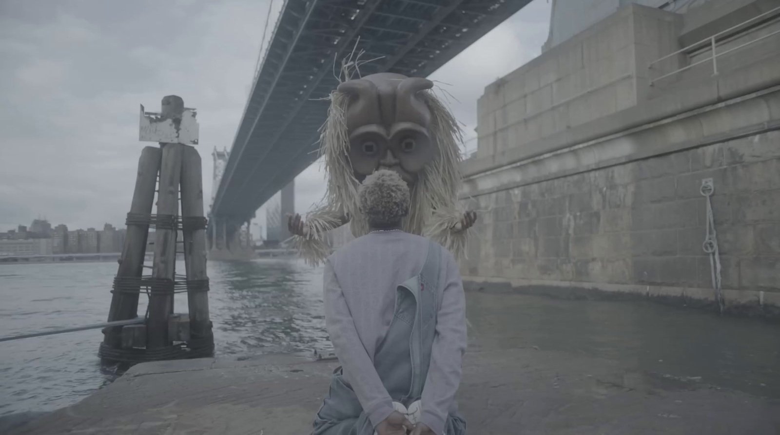 a person with a stuffed animal in front of a bridge