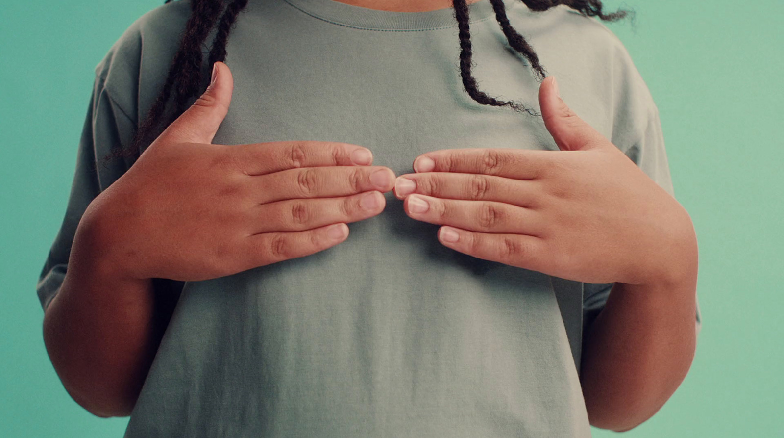 a person with dreadlocks holding their hands together