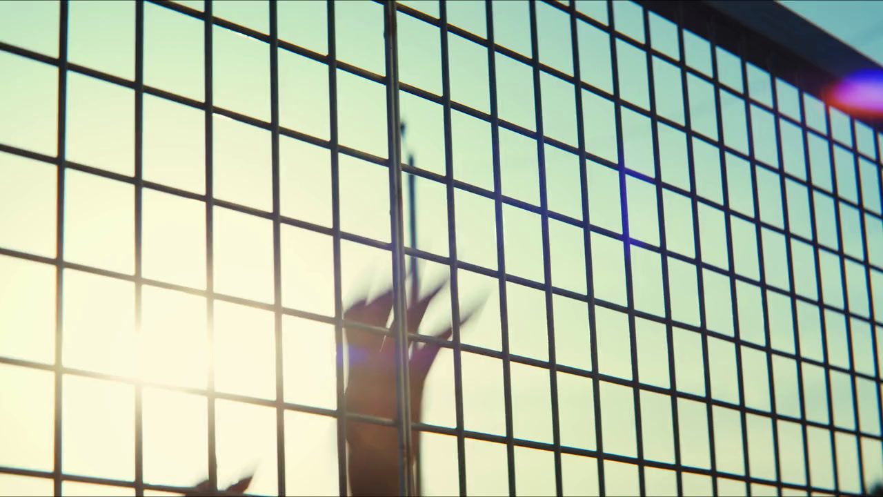 a person reaching up through a metal fence