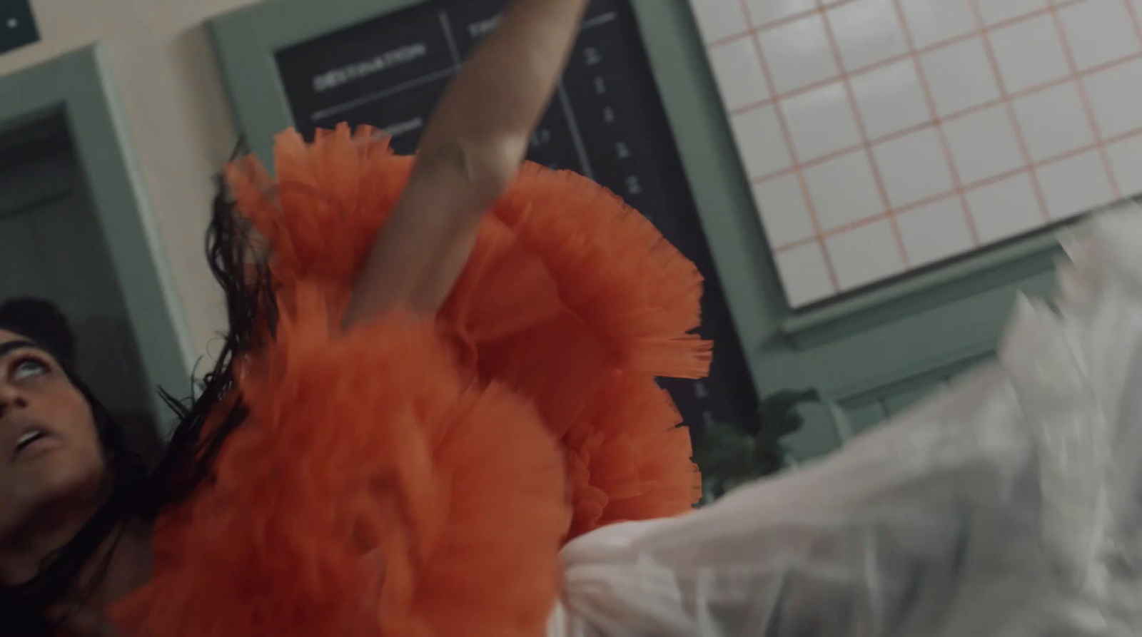 a woman in an orange dress standing in a room