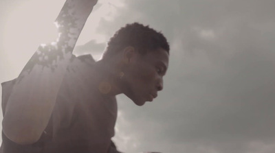 a man holding a pair of skis under a cloudy sky