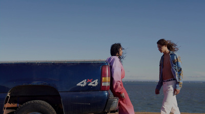 a couple of people standing next to a truck