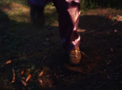 a person walking in the grass with a frisbee in their hand