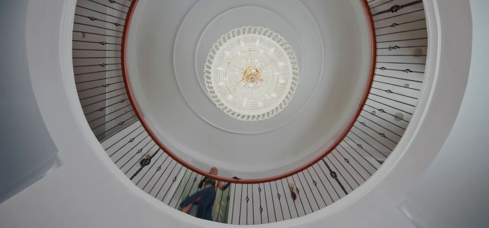 a spiral staircase in a building with people walking up and down it