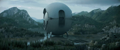 a futuristic looking building in the middle of a forest