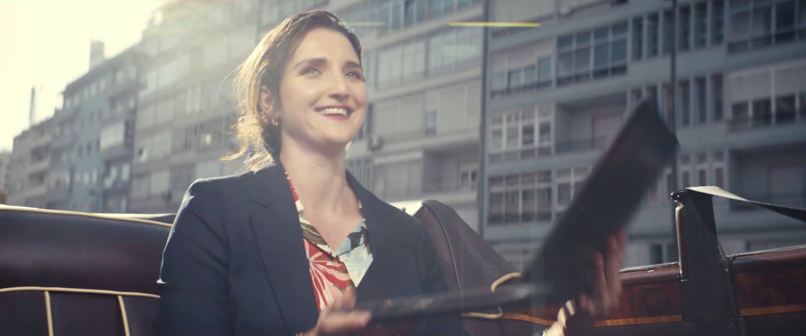 a woman in a business suit sitting in a car