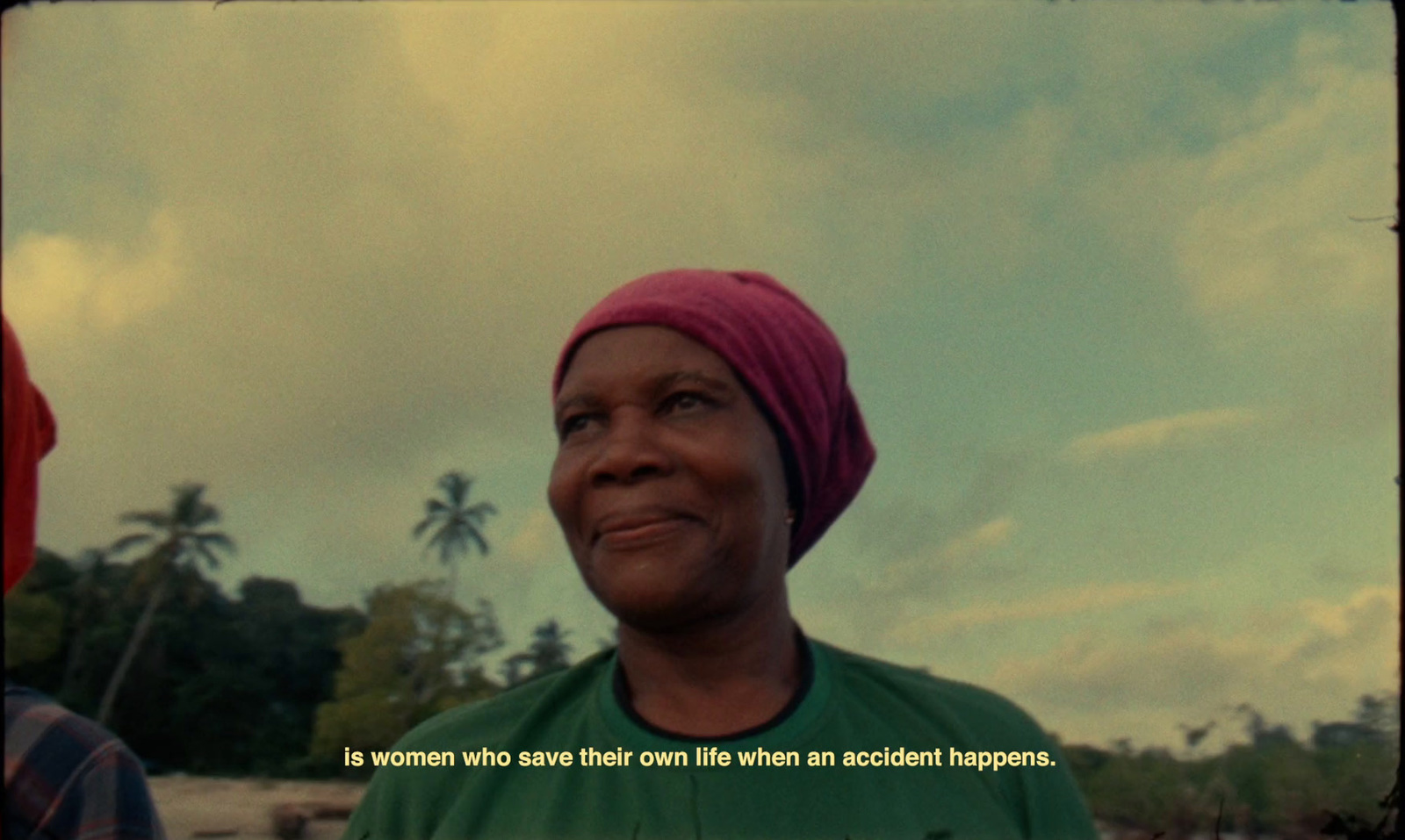 a woman with a pink turban smiles at the camera