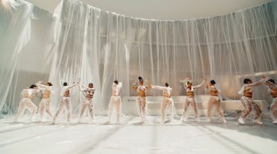 a group of naked people standing in front of a curtain