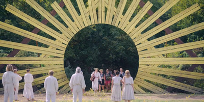 a group of people standing in front of a yellow sculpture