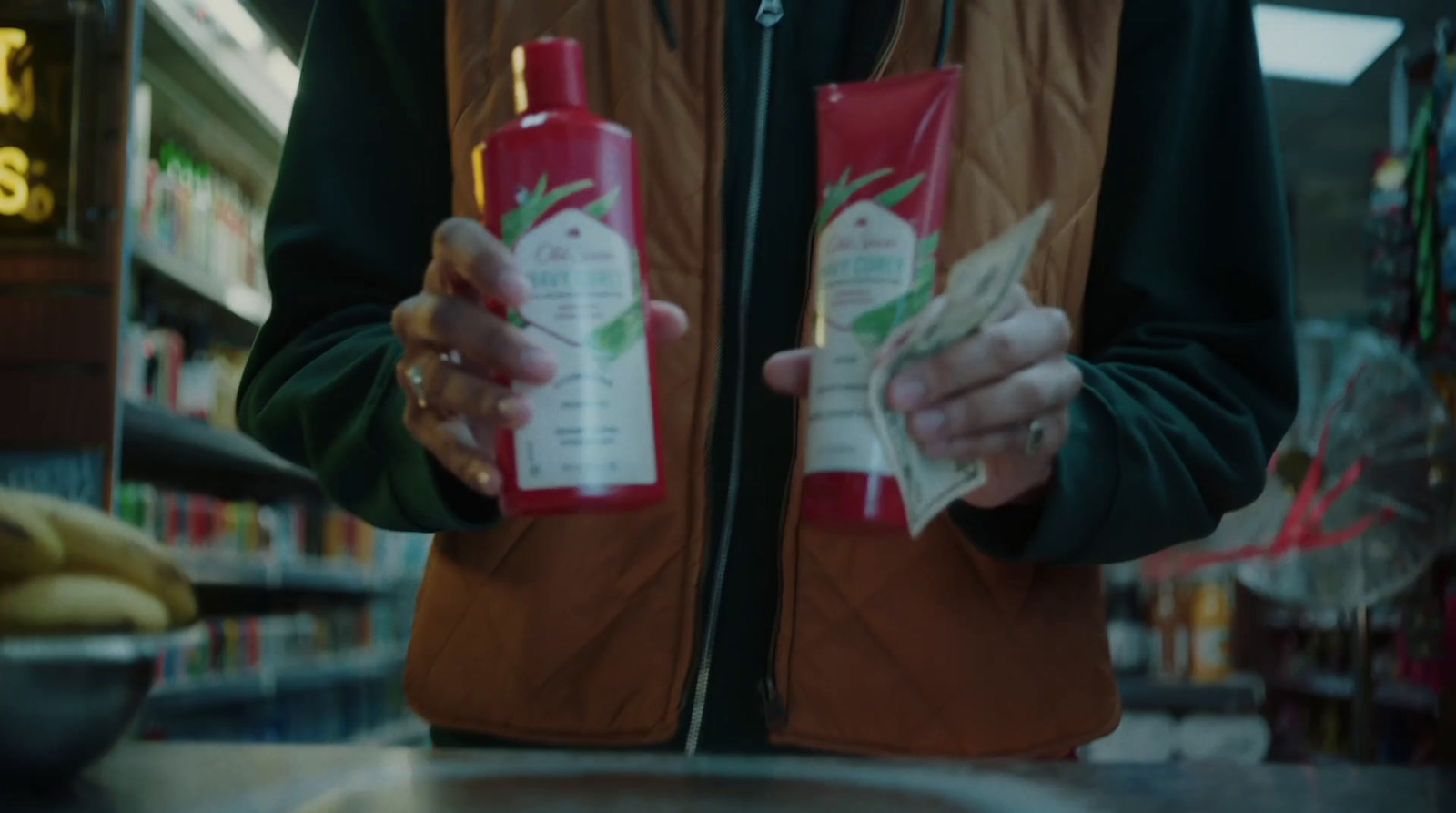 a person holding a bottle of ketchup in a store