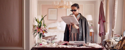 a woman standing in a room holding a piece of paper