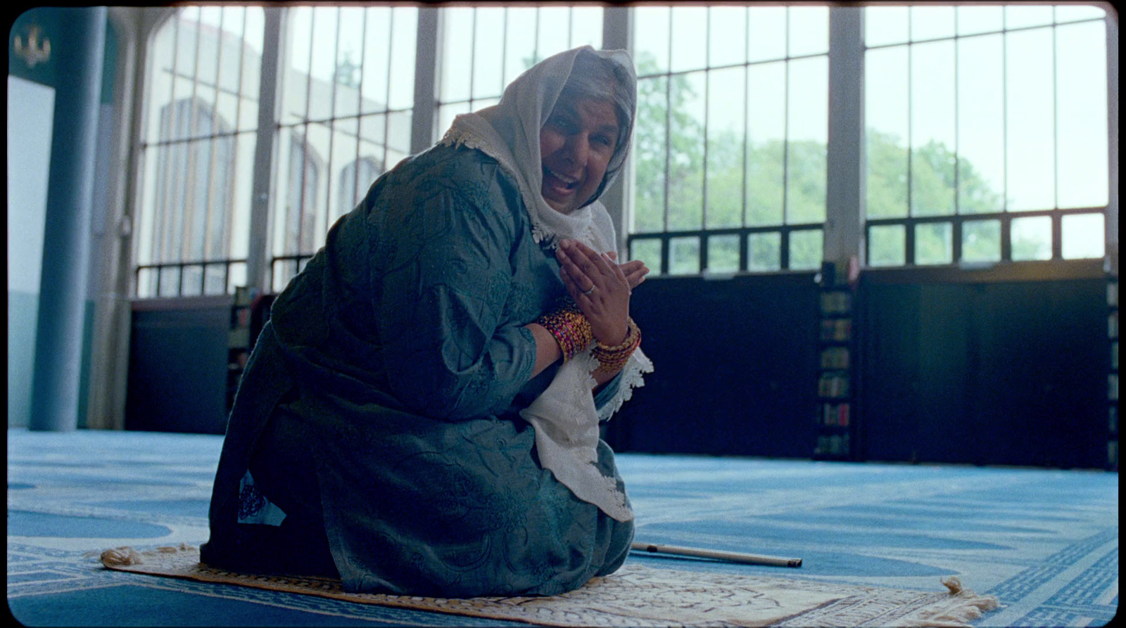 a woman sitting on the ground with her hands together