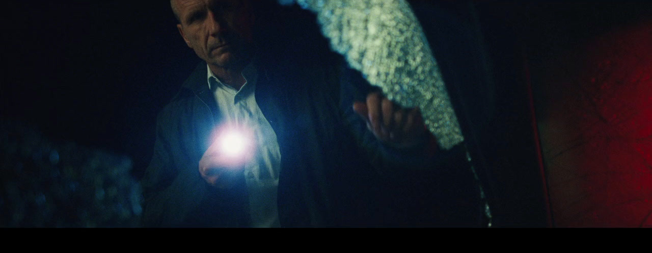 a man holding a flashlight in a dark room