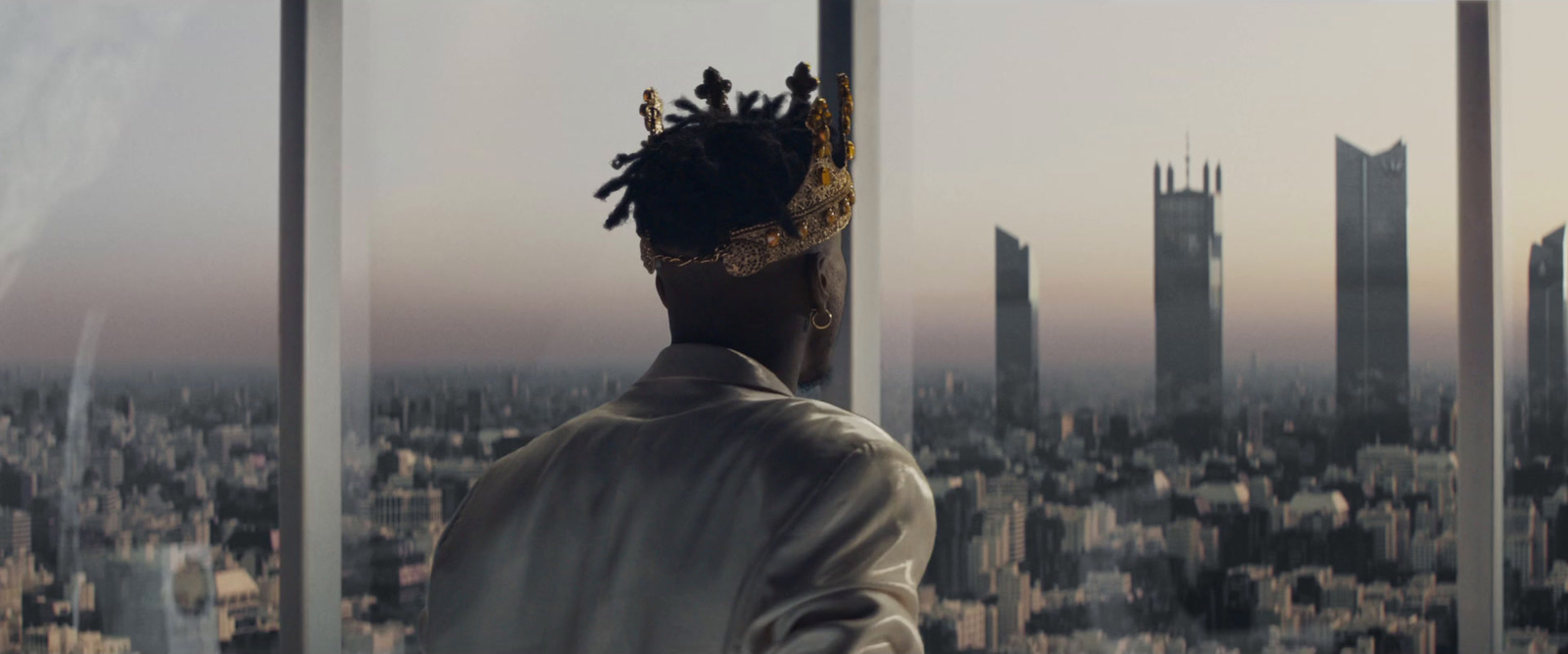 a man looking out a window at a city