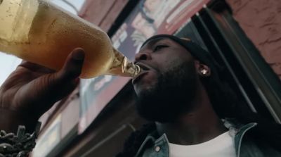 a man drinking a beer from a bottle