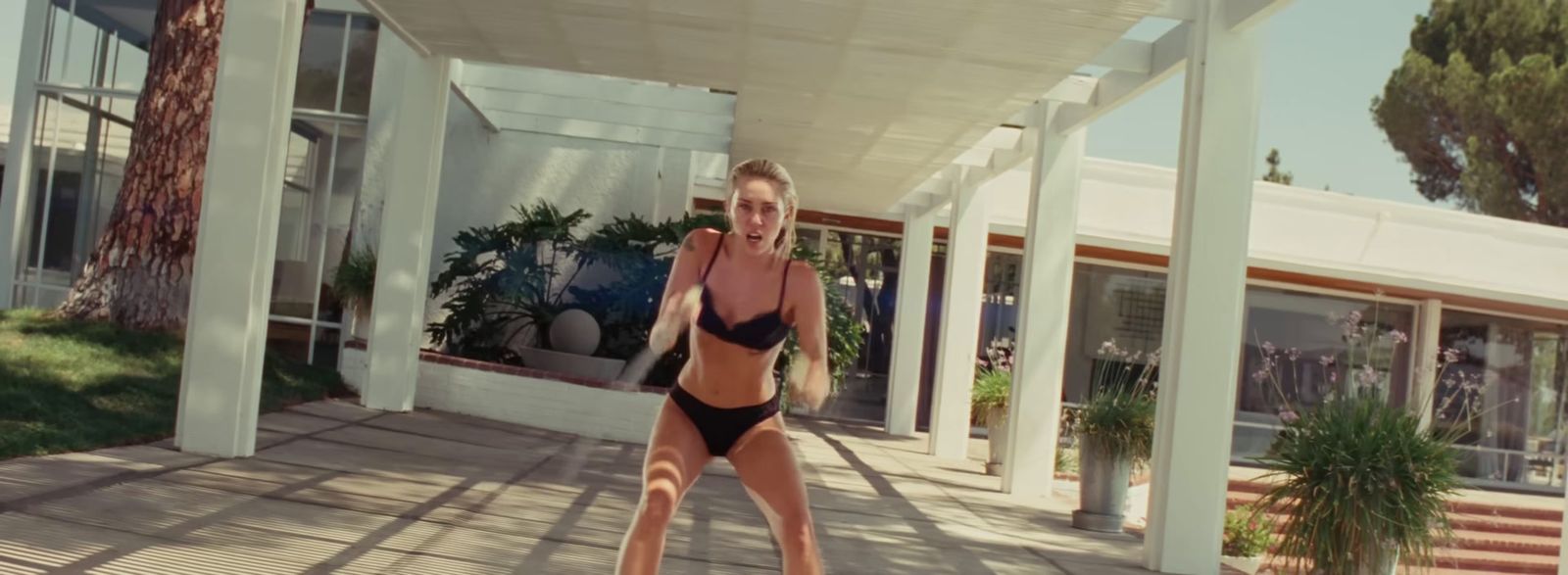 a woman in a bikini standing on a porch