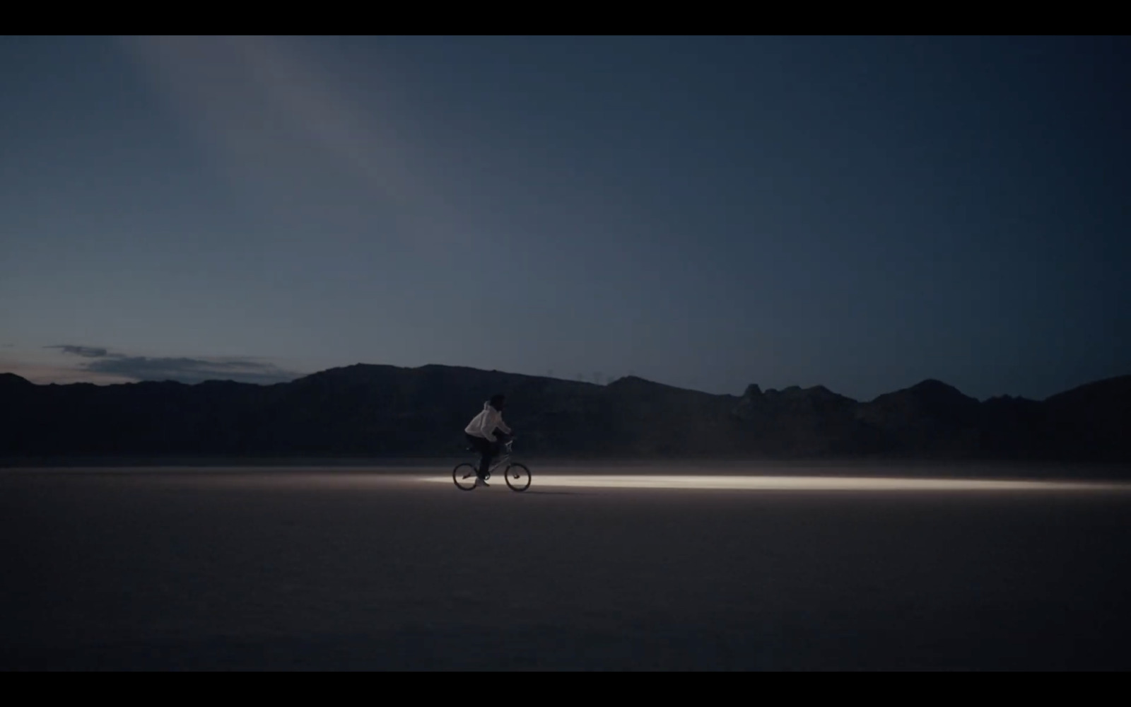 a person riding a bike in the middle of a desert