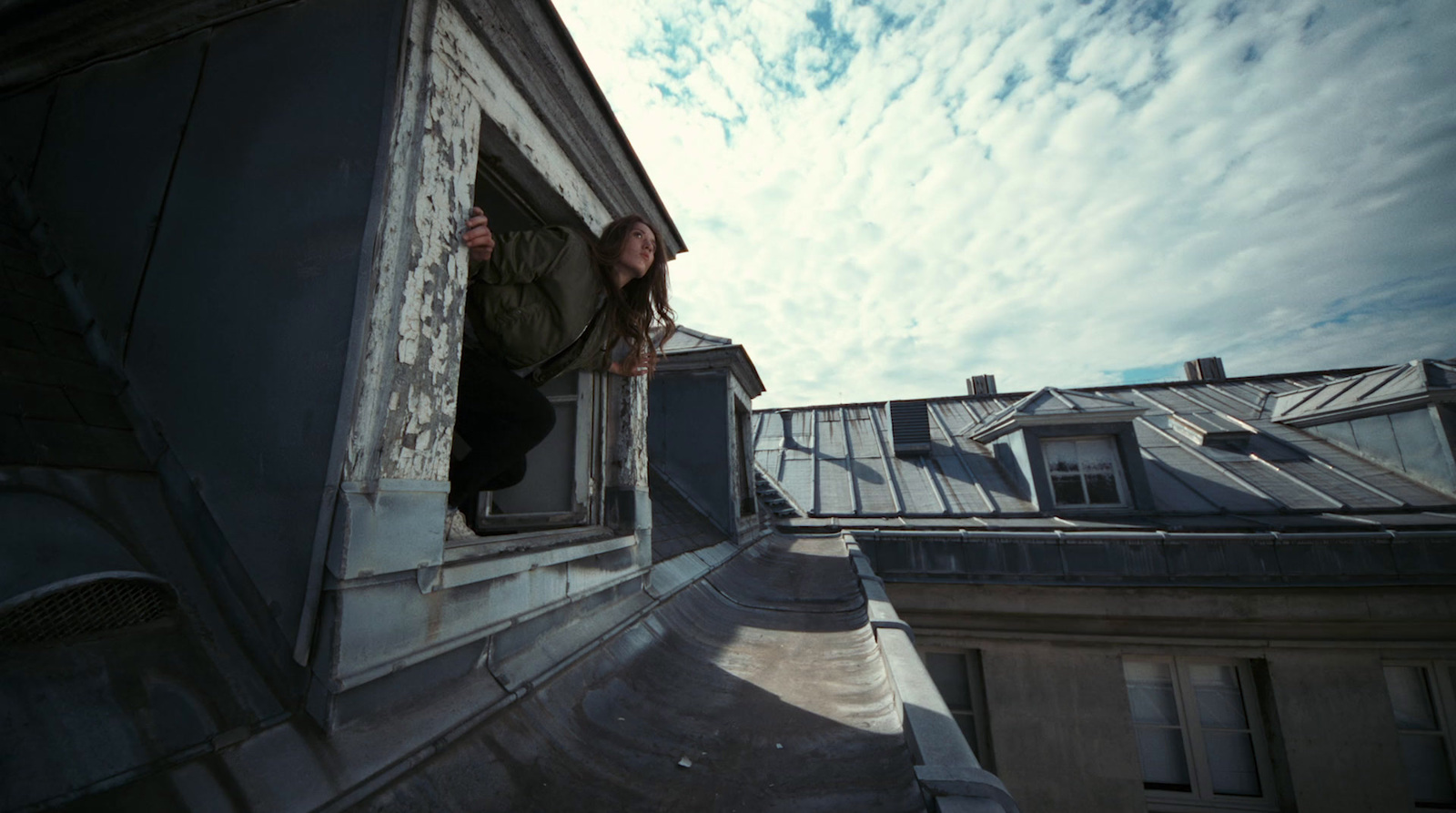 a woman standing on a ledge of a building