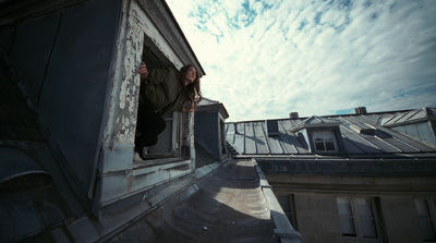 a woman standing on a ledge of a building