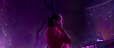 a woman standing in front of a purple light