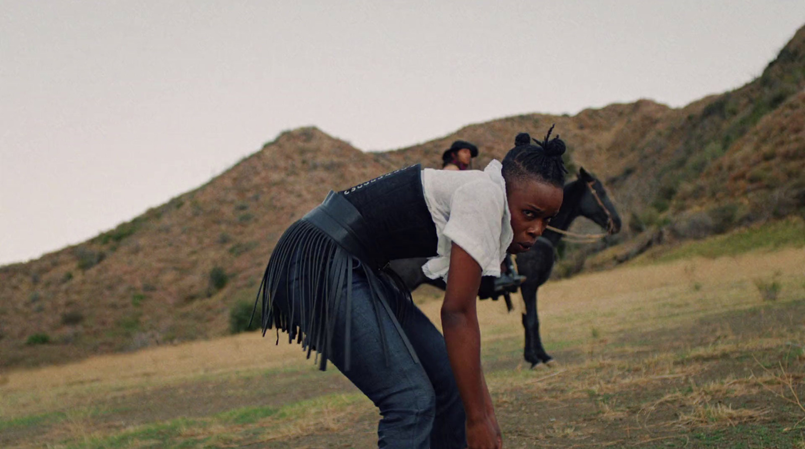 a woman bending down to pick up a frisbee