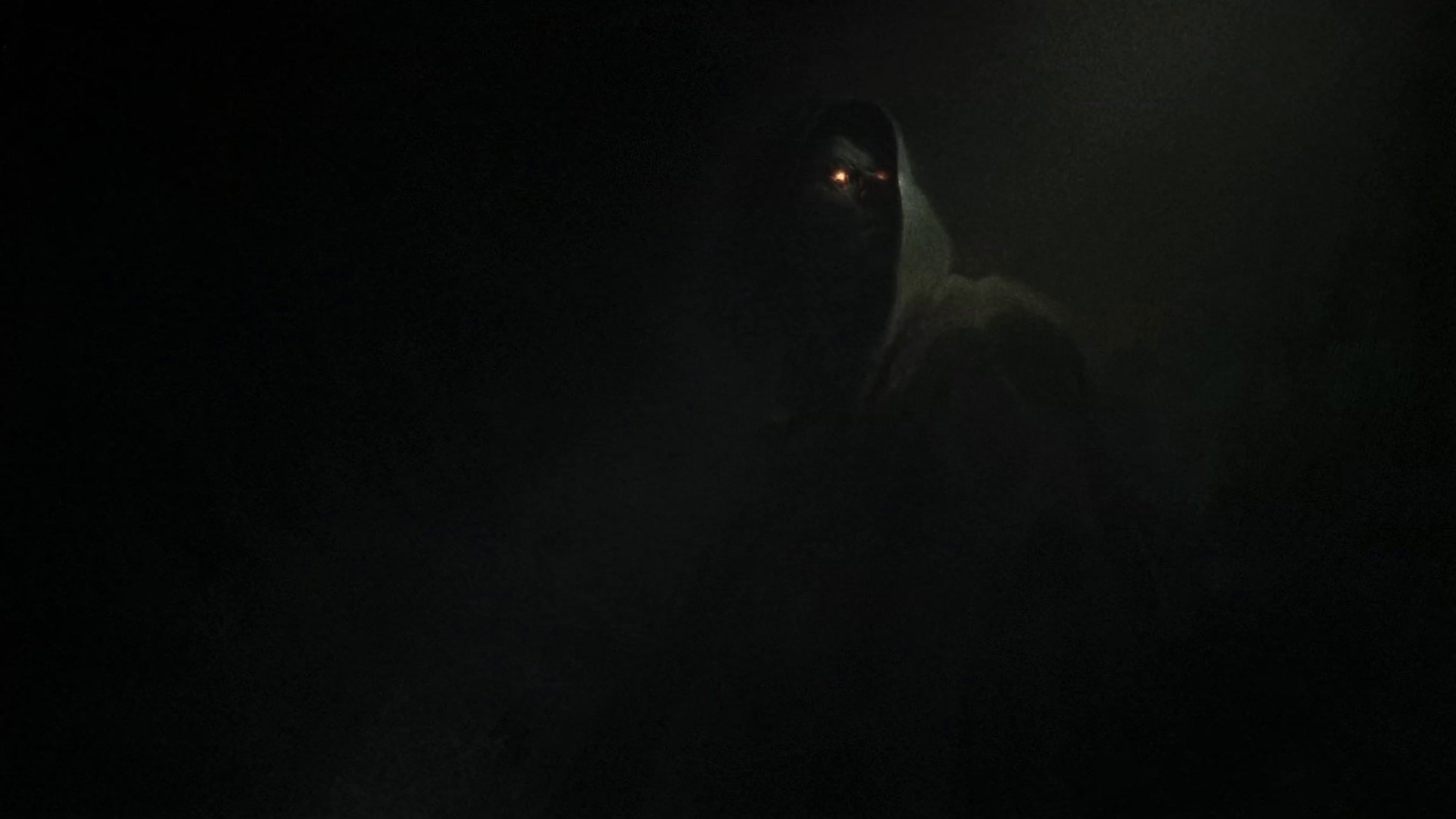 a person in a hooded jacket in the dark