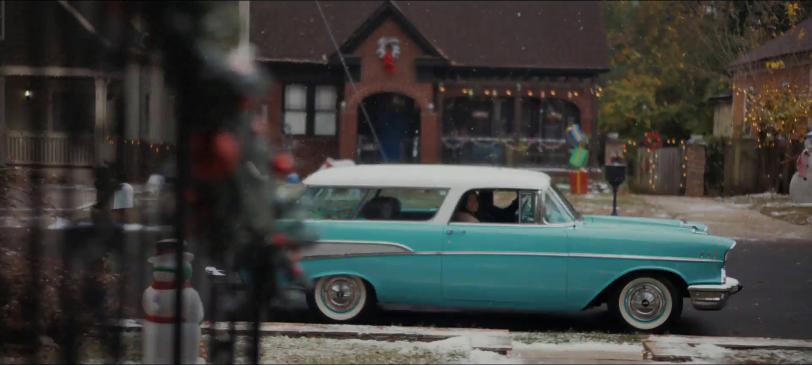 a blue and white car driving down a street