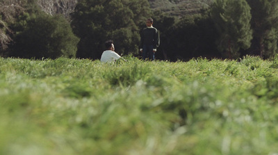 a couple of people sitting in a field of grass