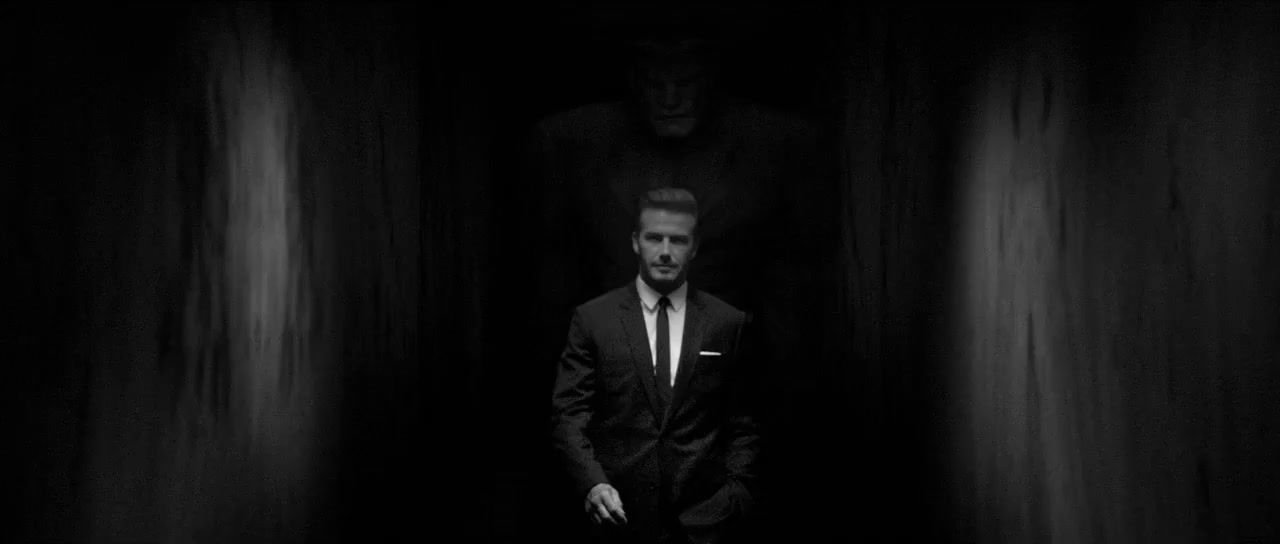 a man in a suit and tie standing in a dark tunnel