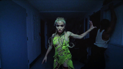 a woman in a neon green dress dancing in a hallway