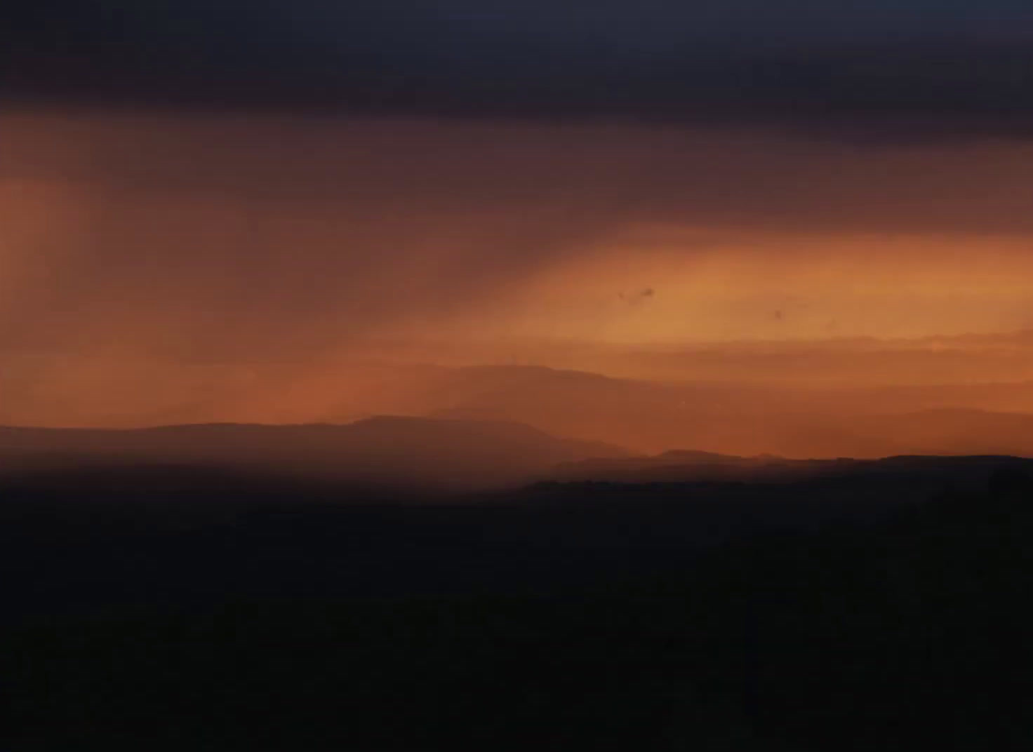 the sun is setting over a mountain range