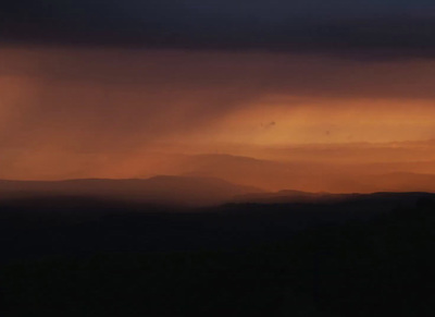 the sun is setting over a mountain range