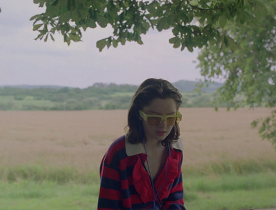 a woman in a red and blue striped shirt is looking at her cell phone