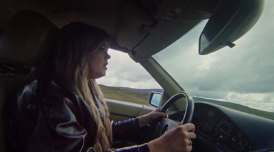 a woman driving a car on a cloudy day