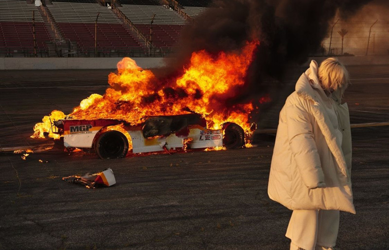 a person standing in front of a burning car